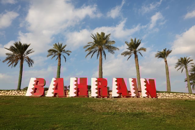 Bahrain landmark sign with palm backdrop