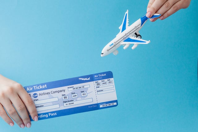 Hand holding plane and ticket