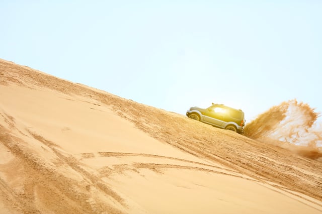 Suv Driving On Desert Dunes