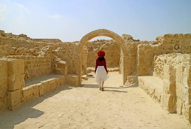Traveller exploring Qal'at al-Bahrain arches